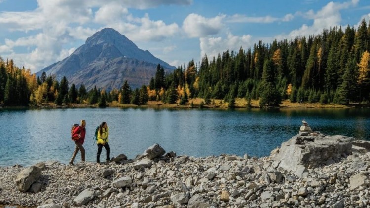 Two people walking around a lake.