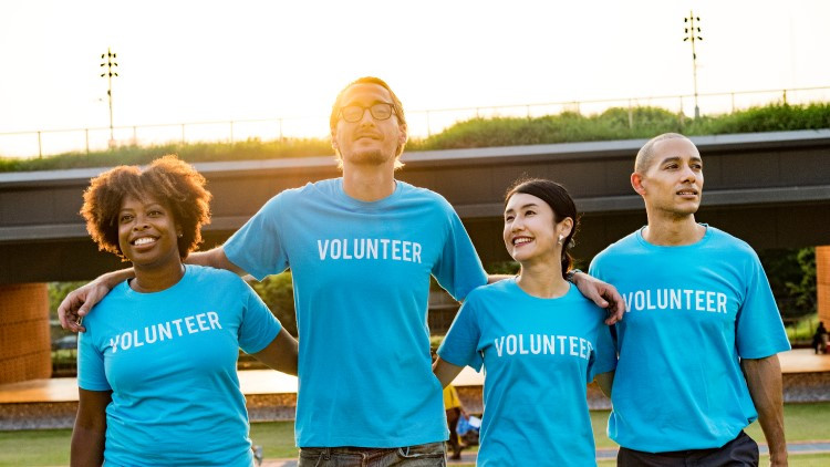 Image of 4 volunteers walking arm in arm
