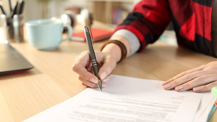 Image of female hands signing document