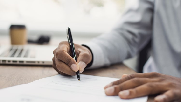 Image of man's hand writing on paper