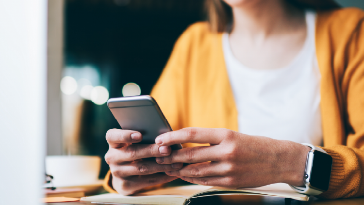 Close up of a woman's hands holding a cell phone