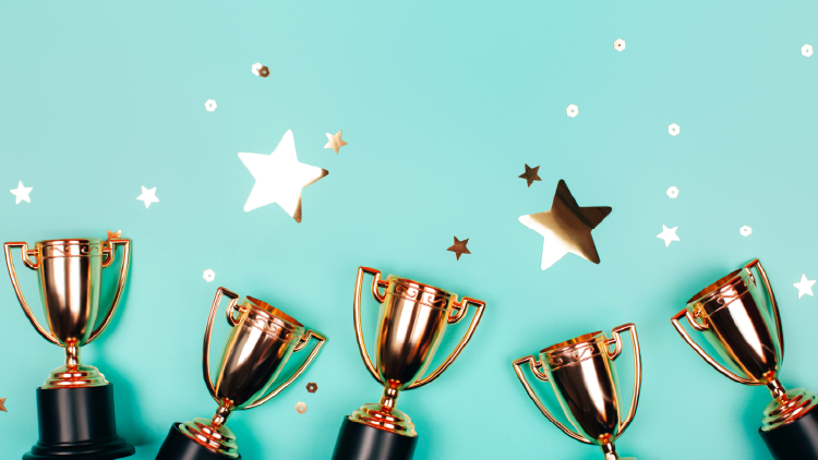 Five trophies on a teal background with gold stars scattered throughout