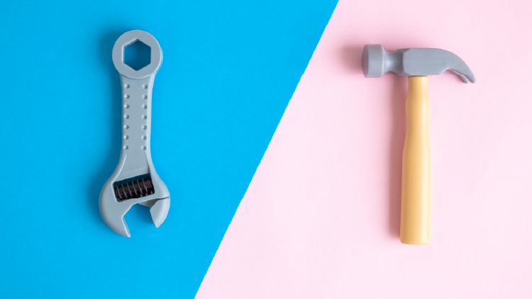 Wrench on a light blue background, hammer on a light pink background, the image background colour is divided in have diagonally