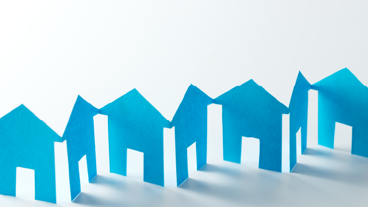 Paper cutouts of blue houses strung along on a white background