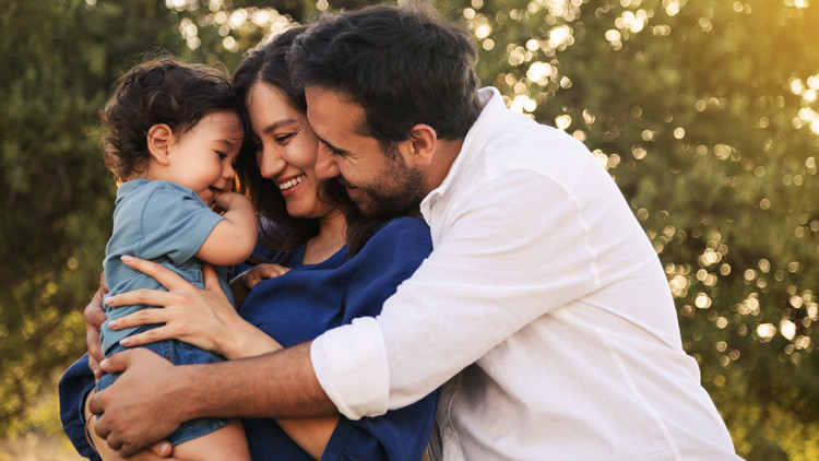 A father and mother hug their child