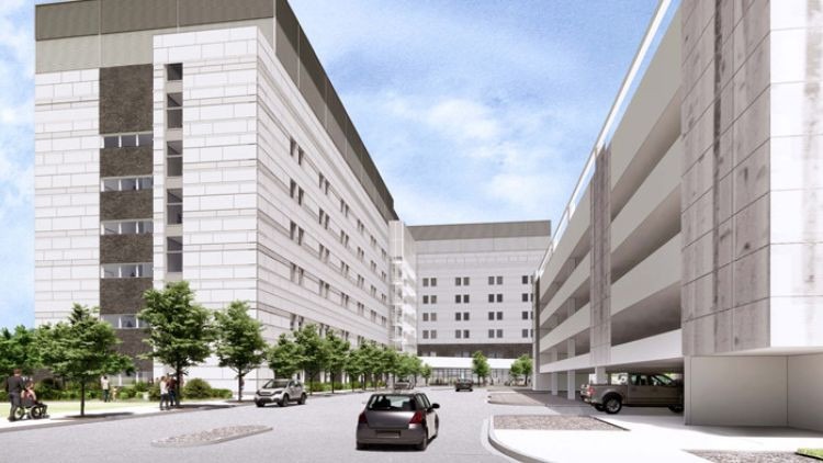 Architectural rendering of the Red Deer Regional Hospital building with a multi-level parking garage, showing street level with cars and pedestrian walkways.