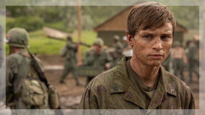 Man in uniform with soldiers in the background