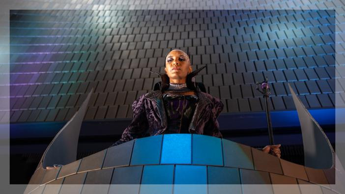 Bald person standing at a podium