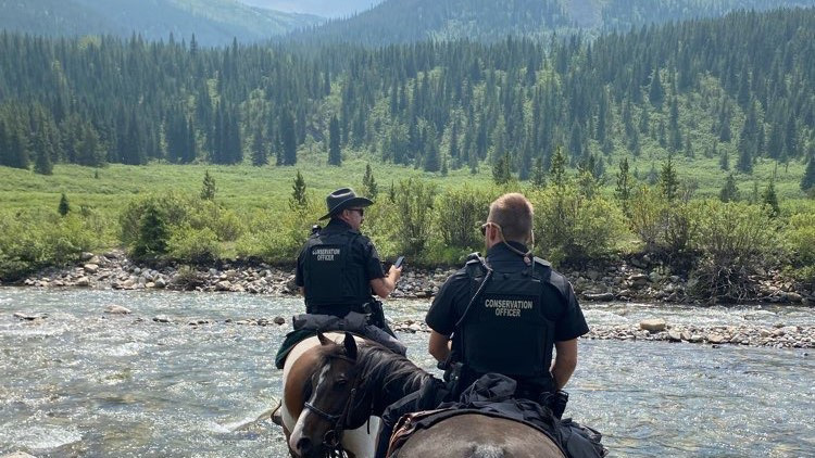 Conservation officers conducting a horse patrol.