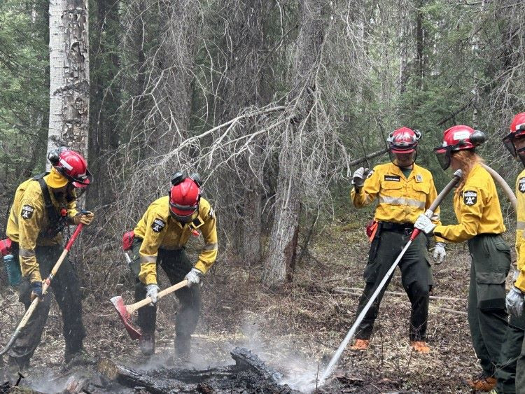 Firefighters are spraying water and digging into a hotspot.