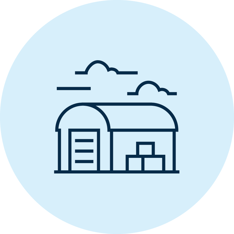Icon featuring a solid blue circle with a black line illustration of a barn and storage bins standing under clouds at the centre