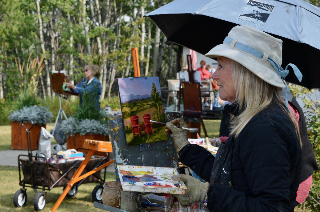 Photo of people painting in the woods.