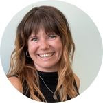 Christina Johnson poses for the camera with a big smile and long, flowing hair