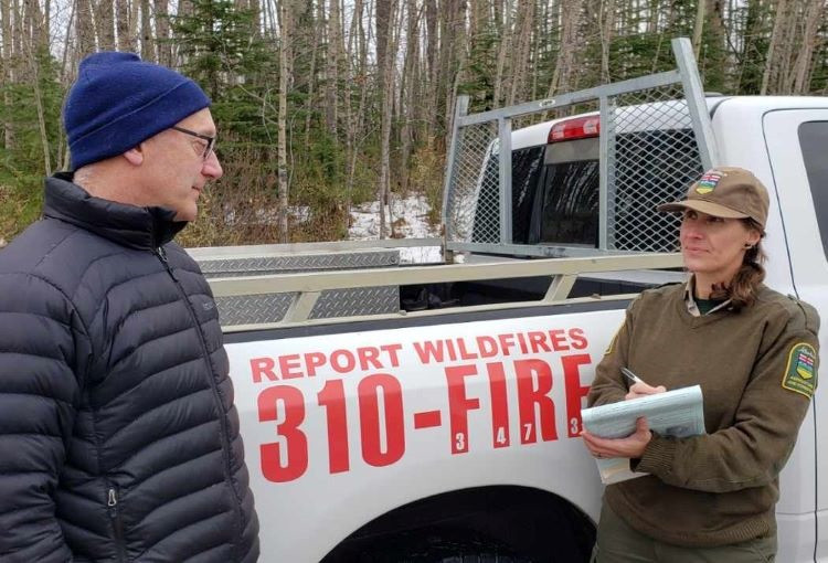 A patrol person writing out a fire burning permit 