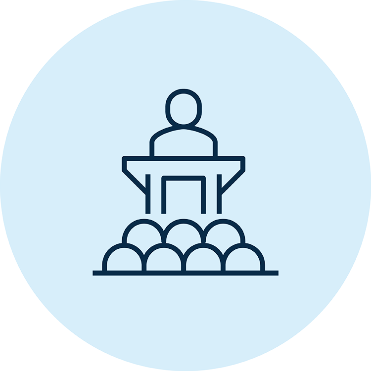 Icon showing a person speaking at a podium in front of other people