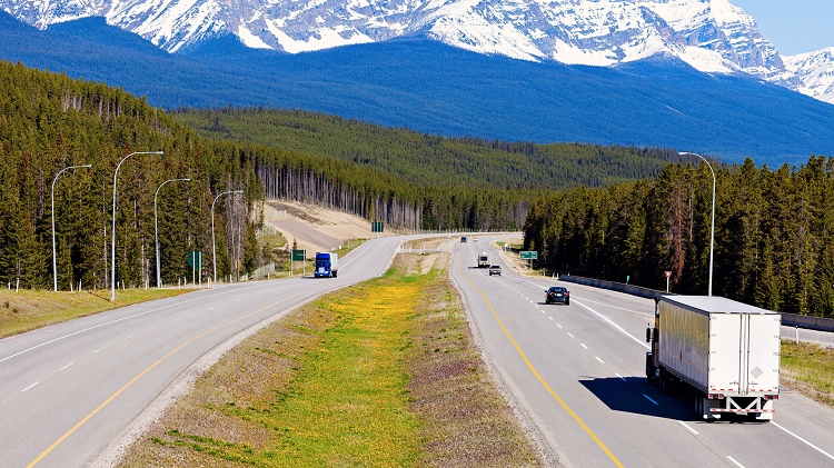 Highway with vehicles and mountain range in the distance