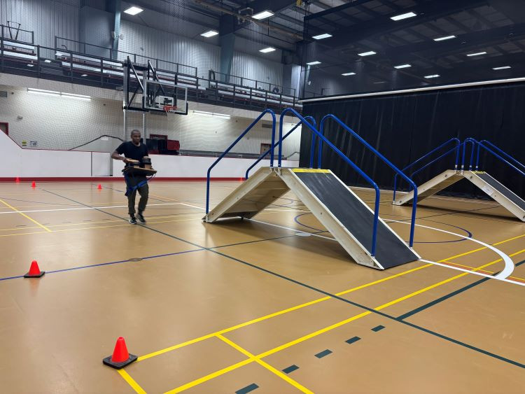 wildland firefighter walking with a pump at fitness testing 