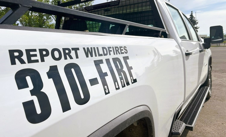 A white pickup truck with a decal showing the words 'Report Wildfires 310-FIRE'.