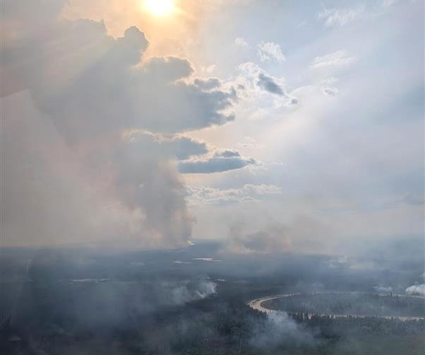 Smoke over a forest and river.