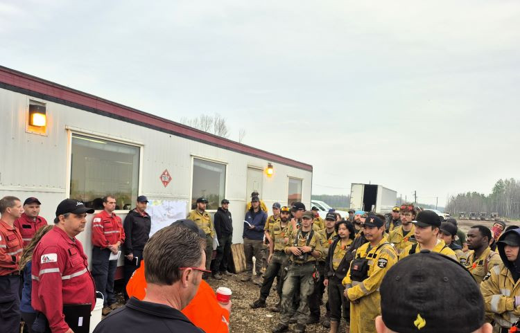 Firefighters with red and yellow shirts standing around facing eachother.