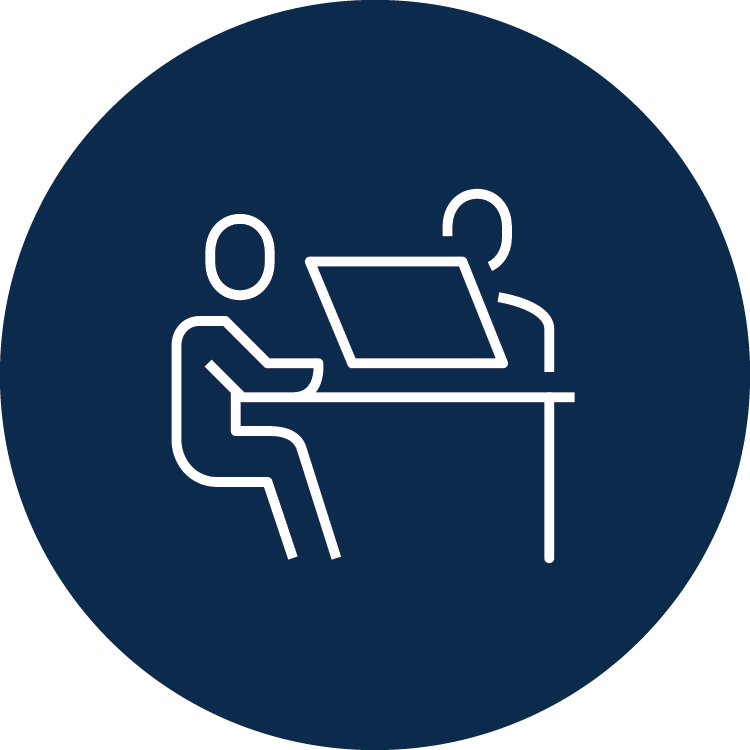 Icon of two people sitting at a desk with a laptop.