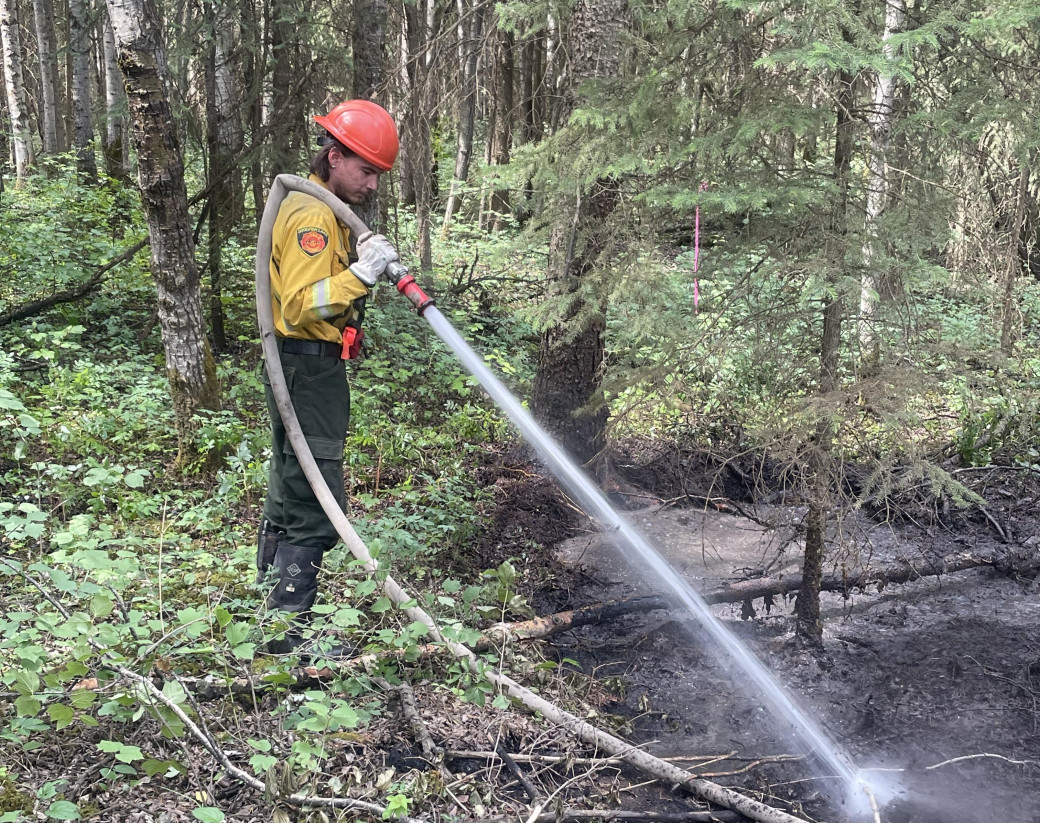 Firefighter extinguishing ground fire