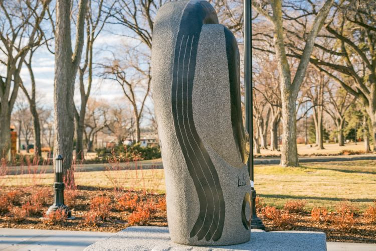 Photo of the side of the residential school monument with four lines depicting four river systems.