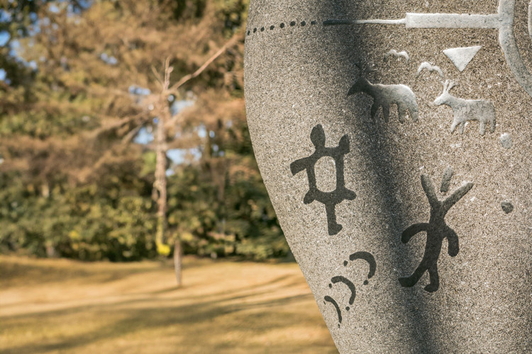 Photo of the Rock Grandfather side of the residential school monument, with petroglyphs that depicting the symbolic effect of residential schools.