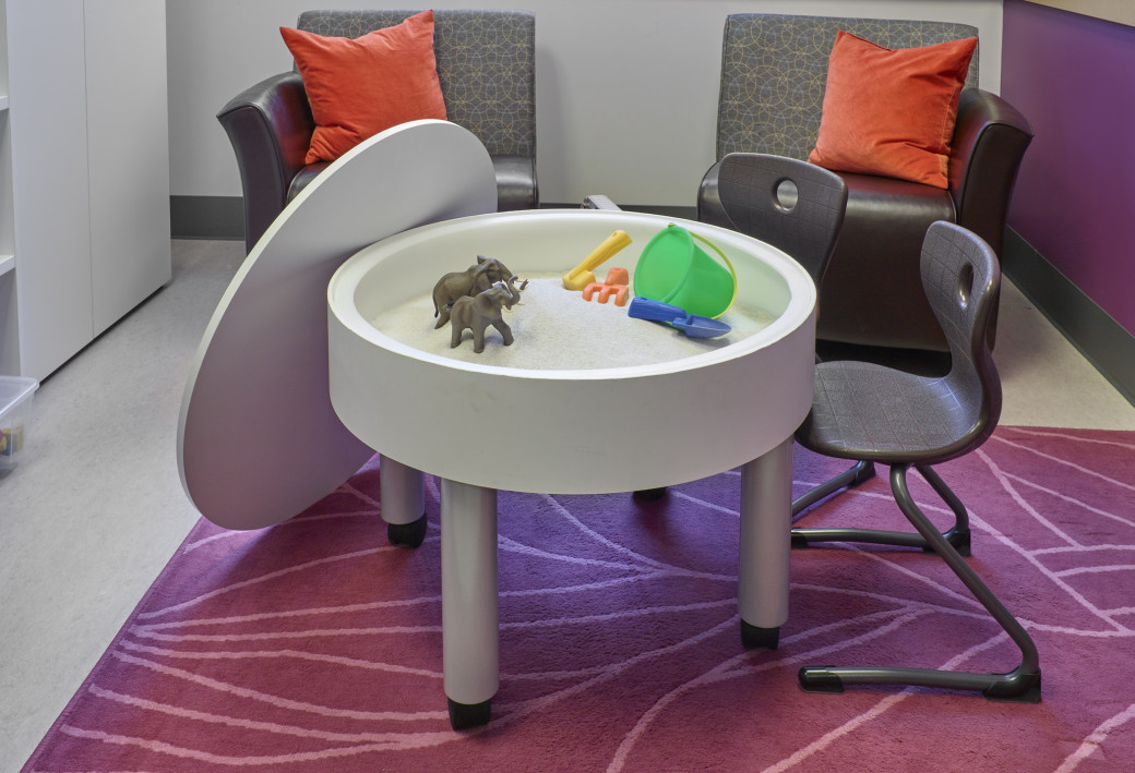 Room with colourful children-sized furniture and toys.