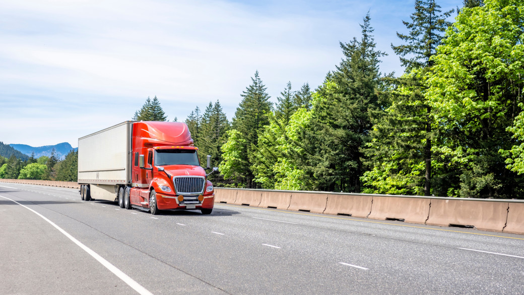Red truck driving through the mountains.