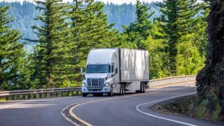 White truck driving through the mountains.